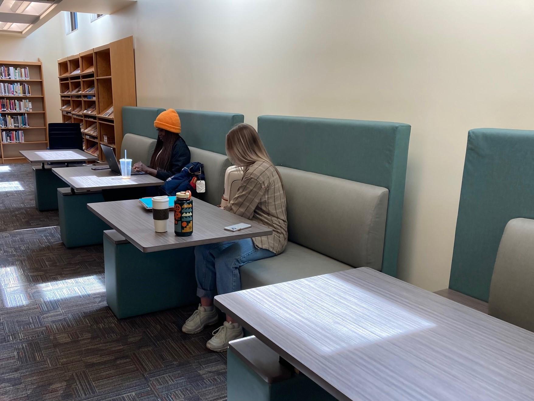 Students seated at new booths in the library