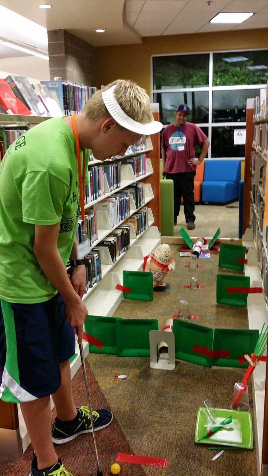 Person mini golfing in a library