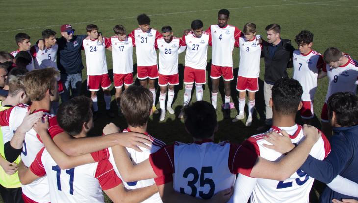 Chad Gilbeck (at left wearing hat) is the chaplain/advisor for the Viterbo men's soccer team.