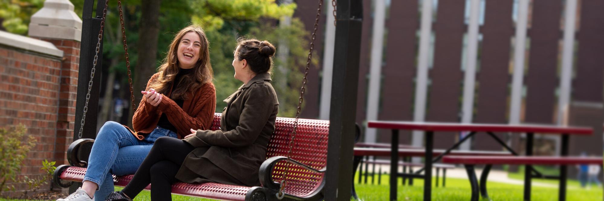 Two people sitting on bench in Viterbo courtyard laughing