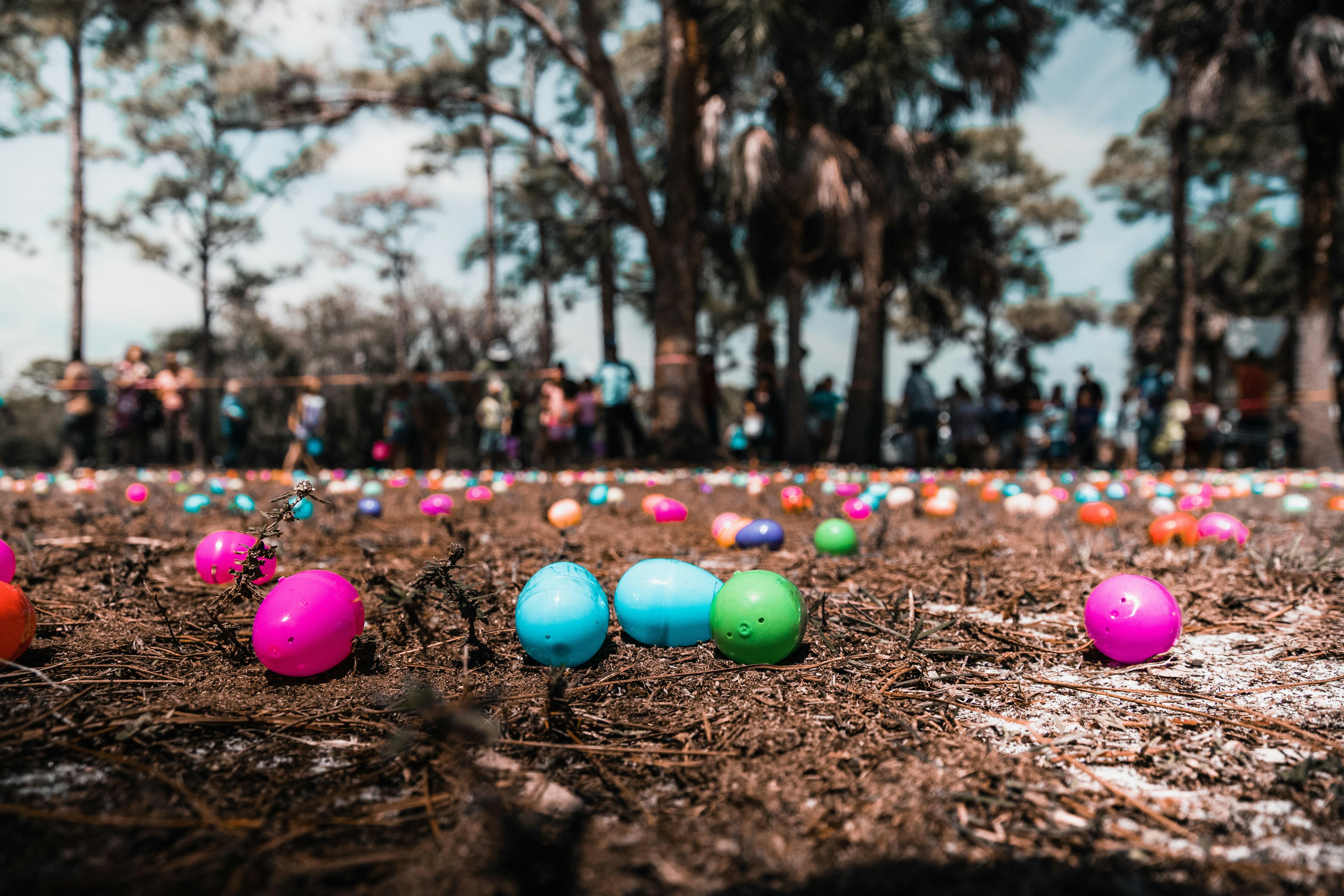 Photo of children lined up for an Easter egg hunt with plastic eggs in the foreground.