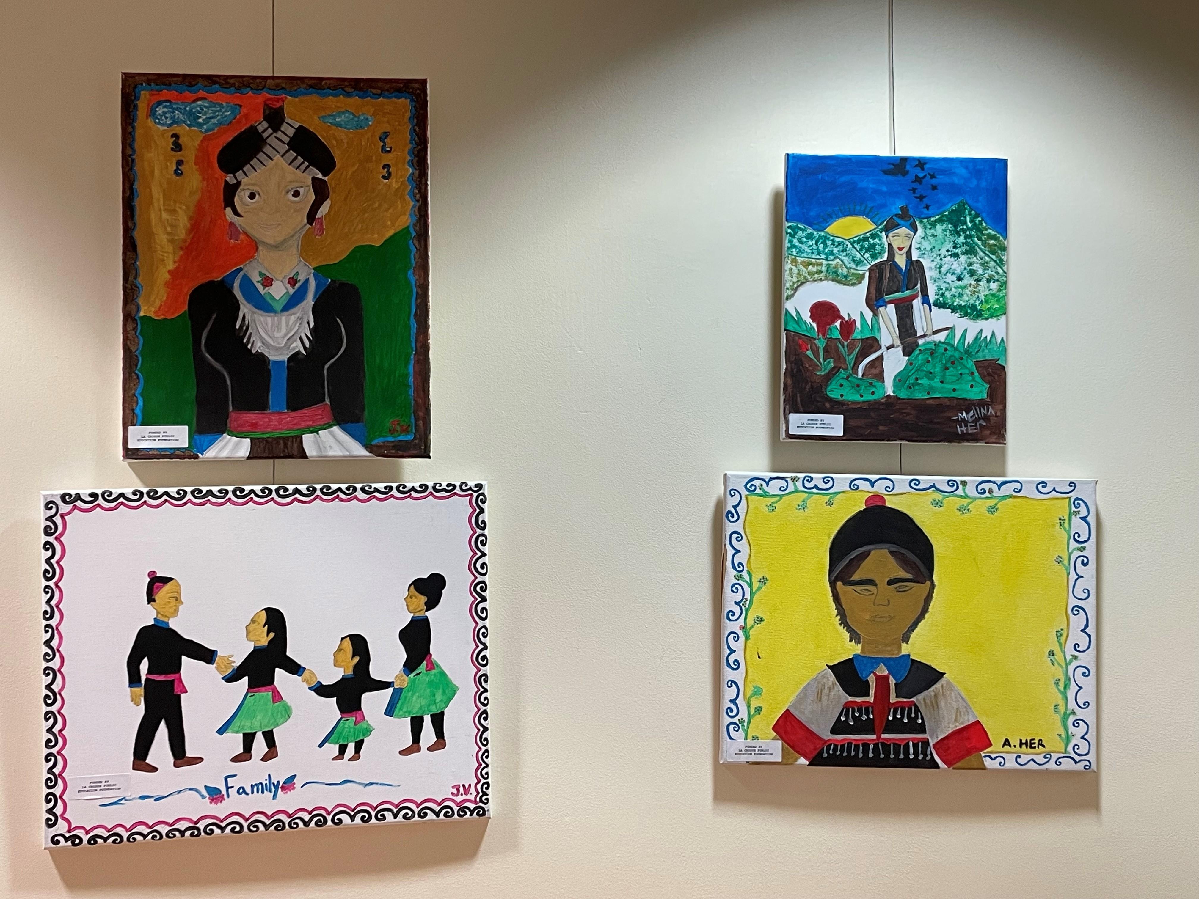 Photo of four of the Hmong paintings on display