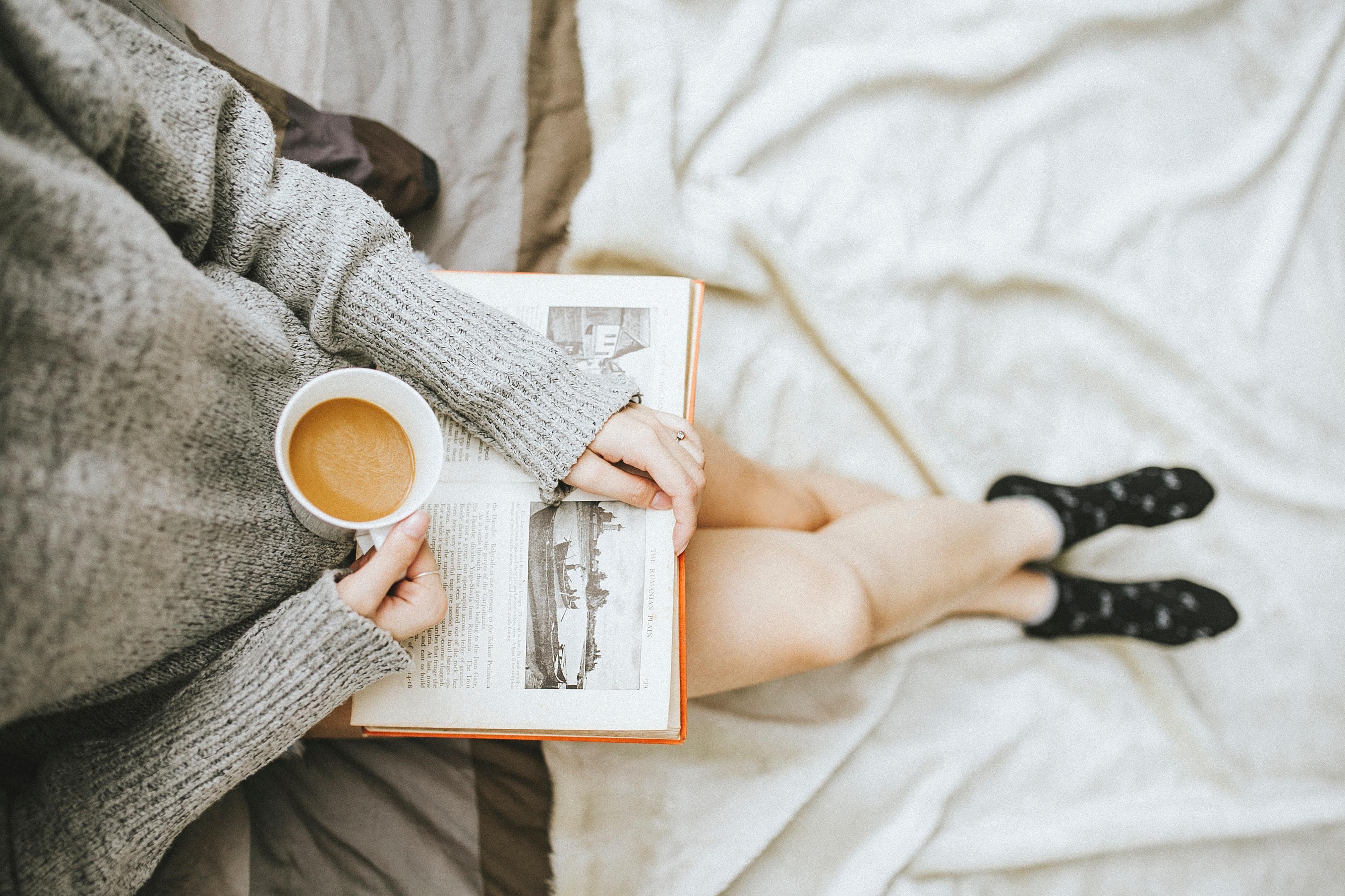 Woman relaxing with a cup of coffee and a book
