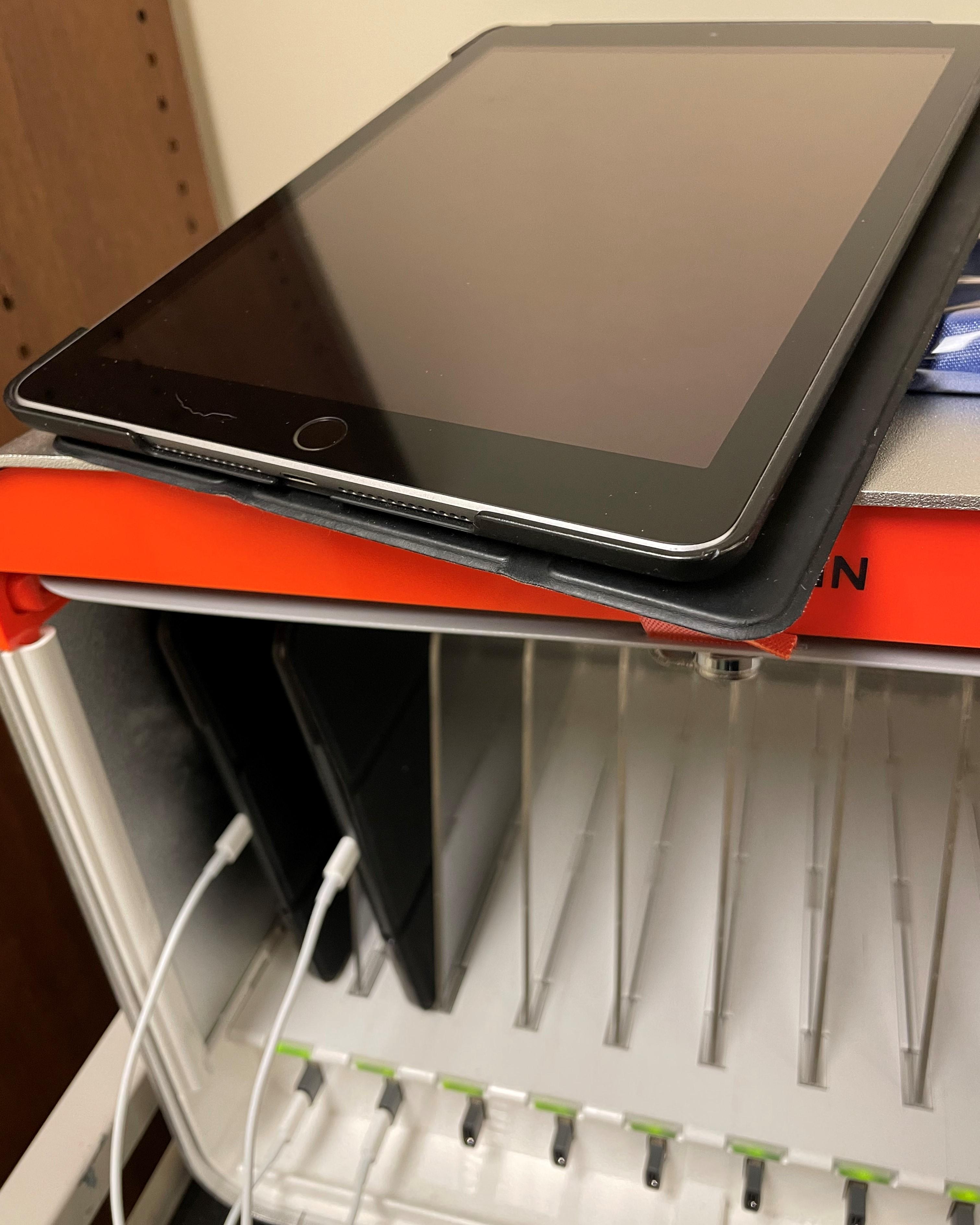 iPad sitting on top of the iPad charging station with more iPads in it