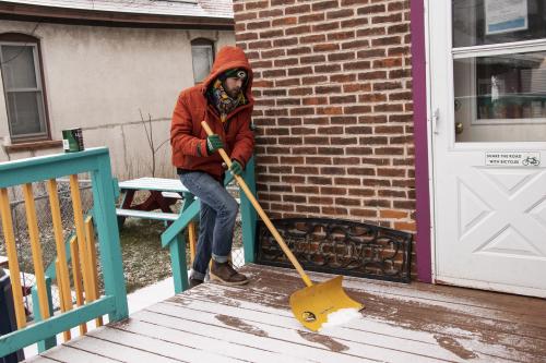 Place of Grace house coordinator Alex Diciaula, clears snow as he awaits the weekly delivery to the food pantry from Hunger Task Force. He completes work on his master’s degree in mental health counseling at Viterbo this semester. 