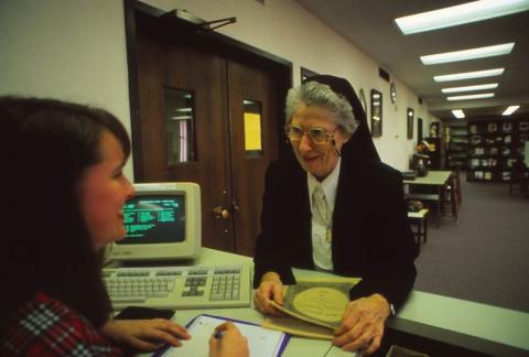 Sister Annarose Glum checks out a music score in the library, October 1994